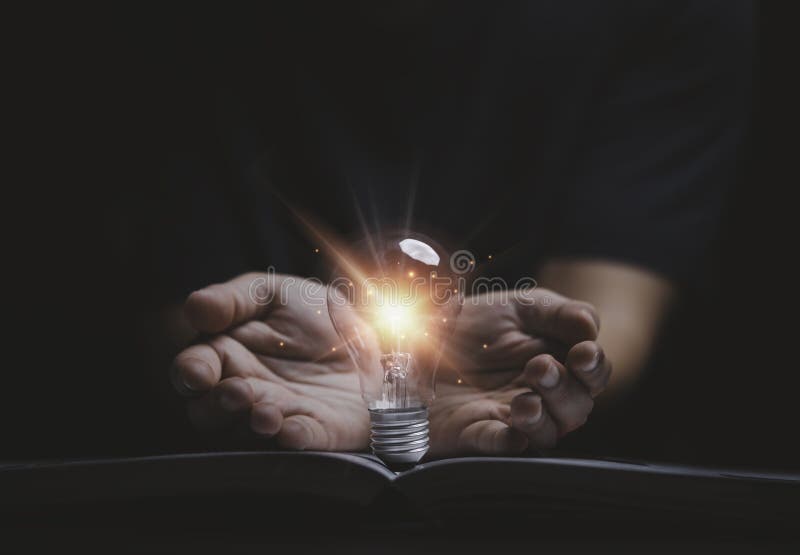 Hand giving glowing lightbulb on open book for creative thinking idea to solve problem from learning knowledge and innovation royalty free stock photography
