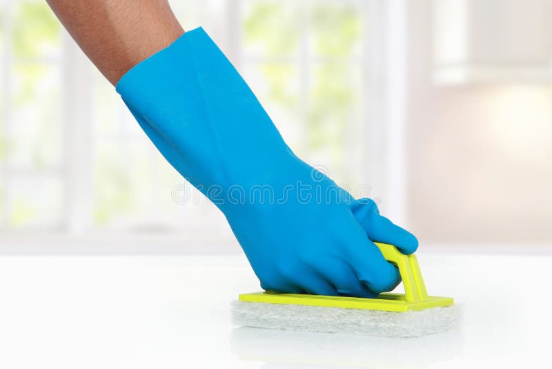 Hand with glove using green cleaning sponge to clean up