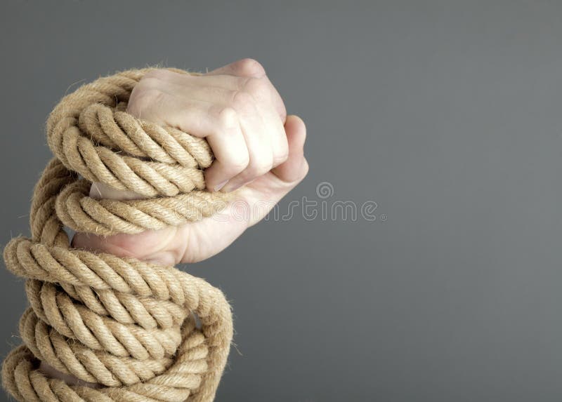 Caucasian male hand gripping coiled or wrapped rope.