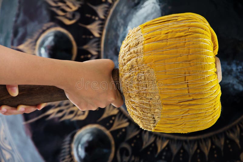 Hand hit big gong in temple