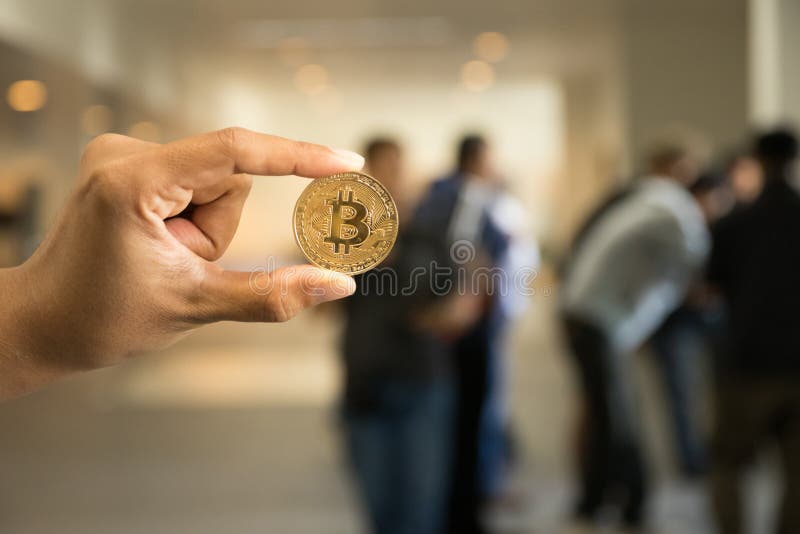 Hand hold Bitcoin on front blurred people meeting background royalty free stock images Hand hold Bitcoin on front blurred people meeting background royalty free stock images