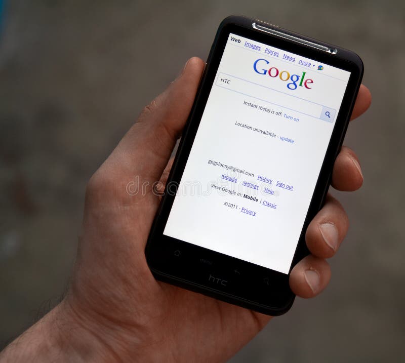 Hand hold HTC Desire HD with Google web page royalty free stock photography