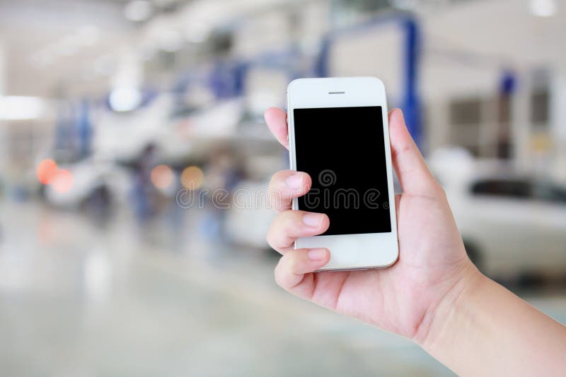 Hand hold smartphone with car repair service center stock photography Hand hold smartphone with car repair service center stock photography
