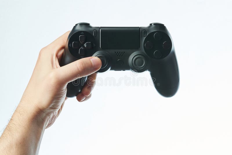 Hand holding black game controller stock photos
