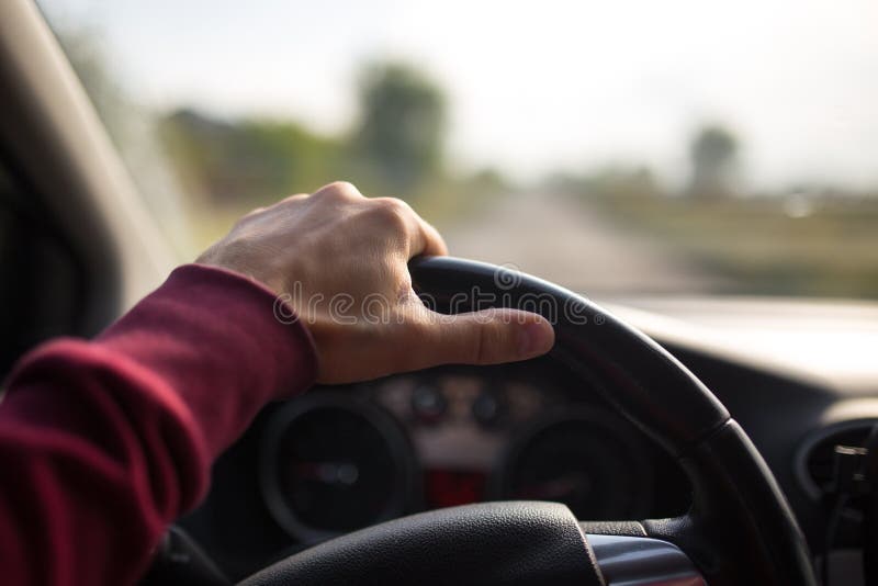 Hand holding on black steering wheel while driving in the car stock photography Hand holding on black steering wheel while driving in the car stock photography