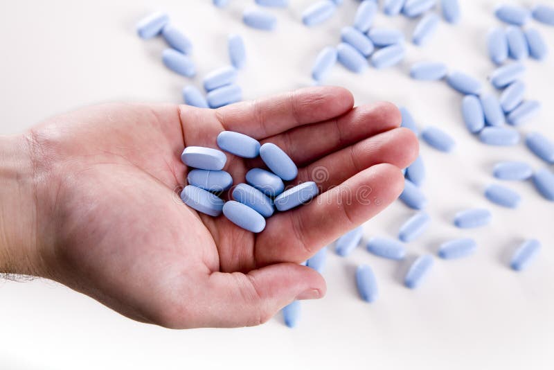 Hand holding blue pills
