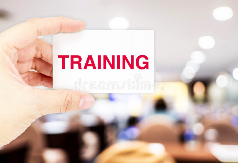 Hand holding Business card with Training word at blur seminar ha stock images Hand holding Business card with Training word at blur seminar ha stock images