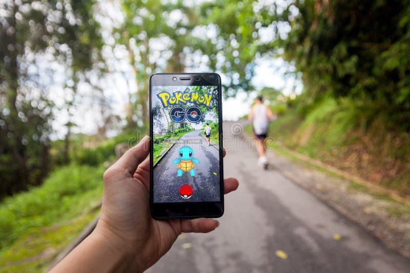 Royalty-Free photo: Person holds smartphone with Pokemon Go application  running