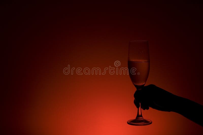 Hand Holding Champagne Glass in Red Light