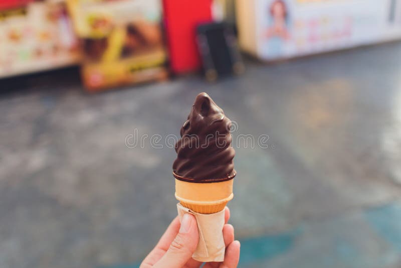 Hand holding chocolate triple scoop ice cream. royalty free stock photo