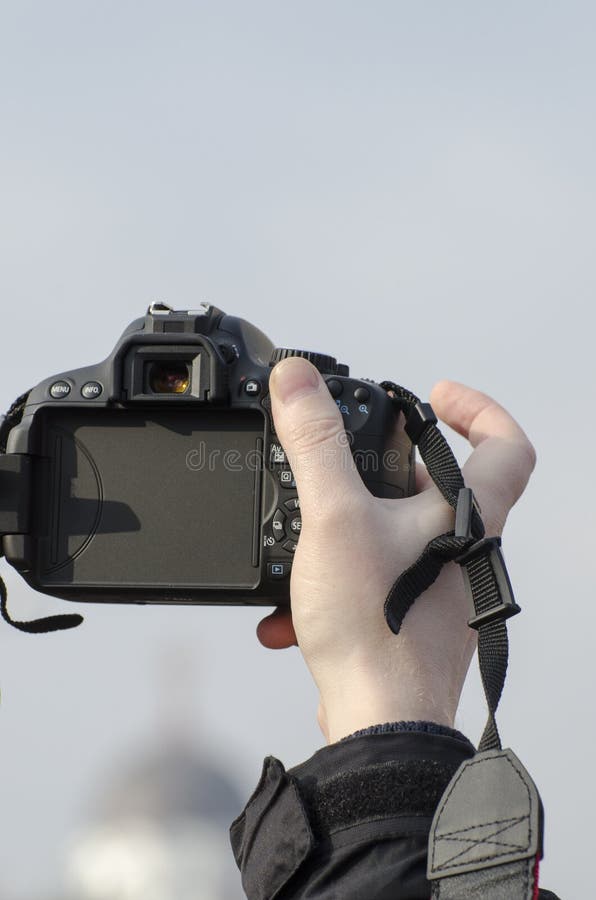 Hand holding DSLR camera stock image. Image of shooting 35654111