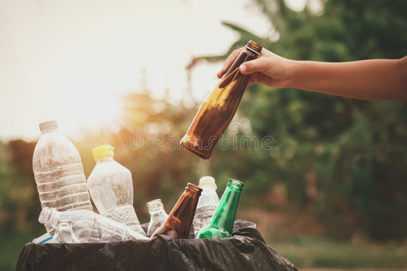 Hand Holding Garbage Bottle Glass Putting into Recycle Bag Stock Photo