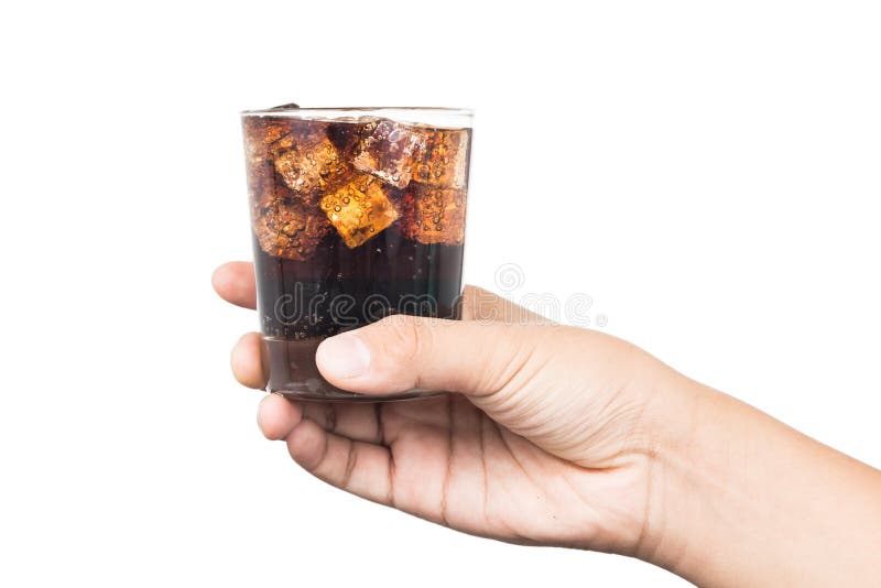 Hand holding a glass of ice filled cold and fizzy cola drink