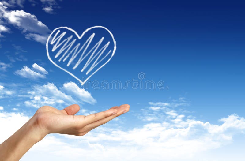 Hand holding heart shape cloud and blue sky