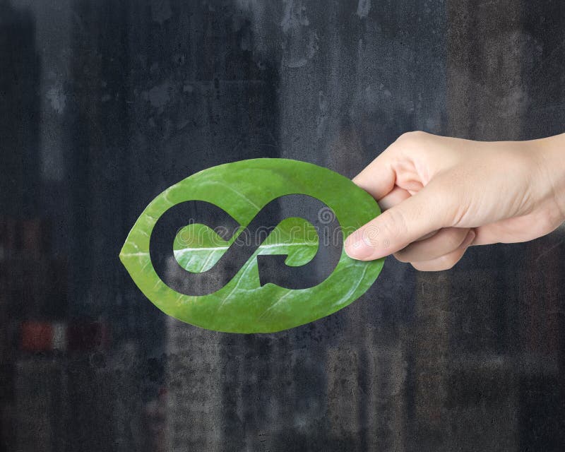 Hand holding leaf with hole of arrow infinity, circular economy stock image Hand holding leaf with hole of arrow infinity, circular economy stock image