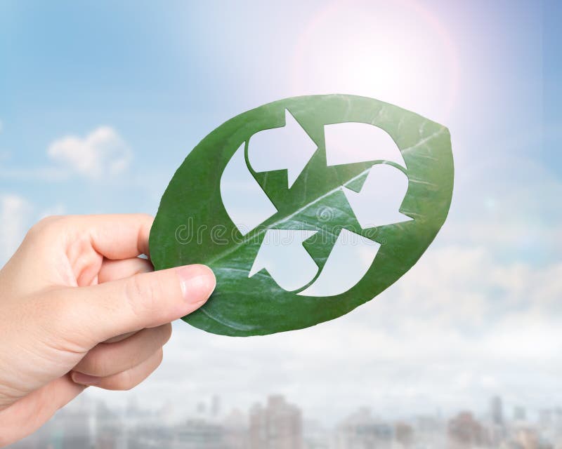 Hand holding leaf with hole of recycling symbol, resource recovery stock photos Hand holding leaf with hole of recycling symbol, resource recovery stock photos