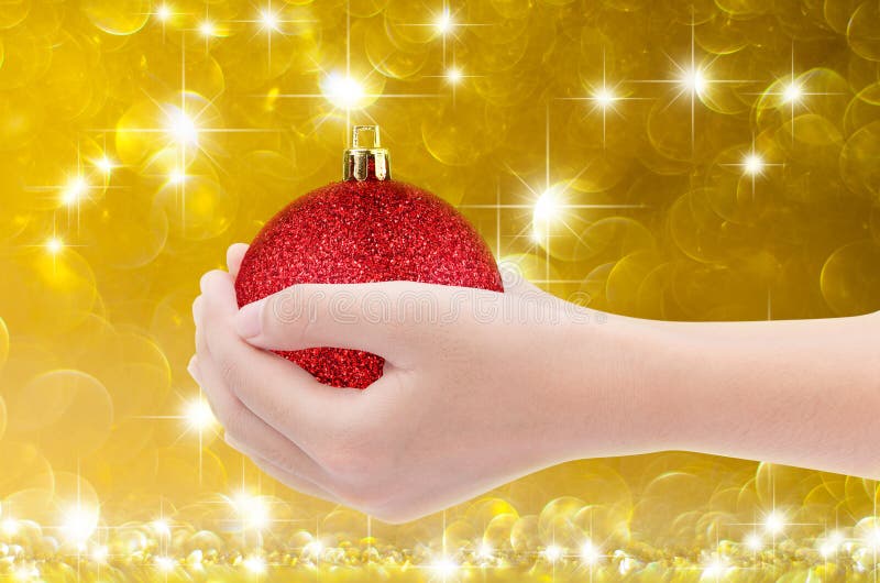 Hand Holding Red Ball On Gold Bokeh Background Stock Photo - Image of ...