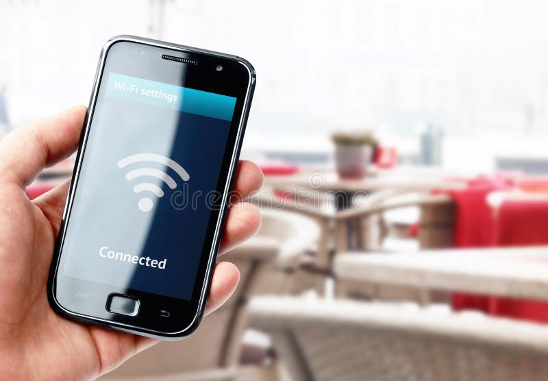 Hand holding smartphone with wi-fi connection in cafe
