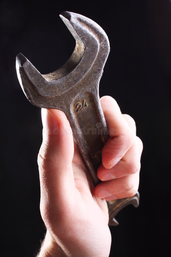 Hand holding spanner; wrench