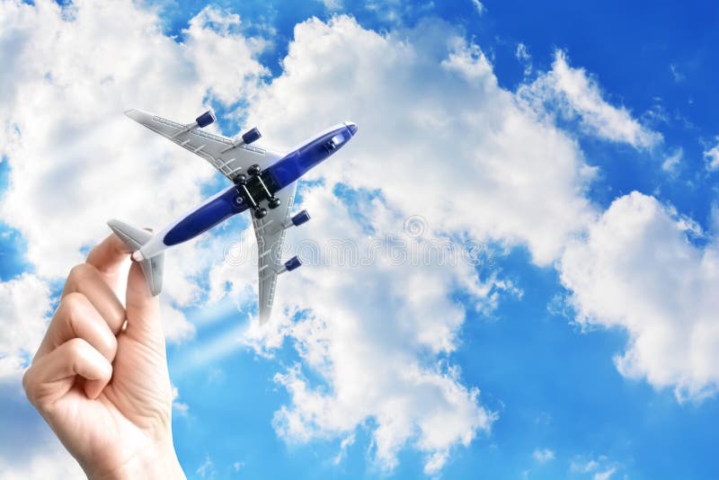 Hand holding a toy plane against blue sky stock photo Hand holding a toy plane against blue sky stock photo