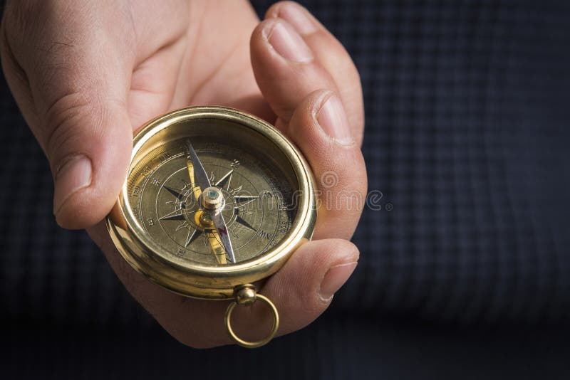 Hand holding a vintage compass with copy space, close up, selective focus