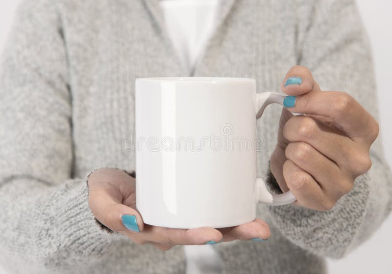 Hand holding white ceramic coffee cup. mockup for creative