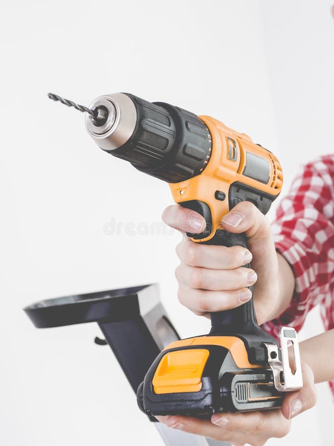 Hand holding yellow drill stock image. Image of tool - 168543333