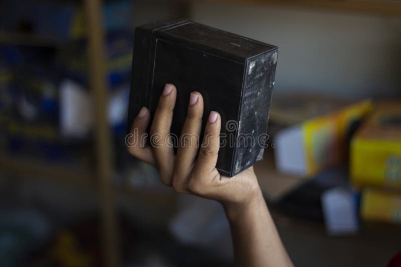 A hand holds a black rectangular object, possibly a battery royalty free stock photos