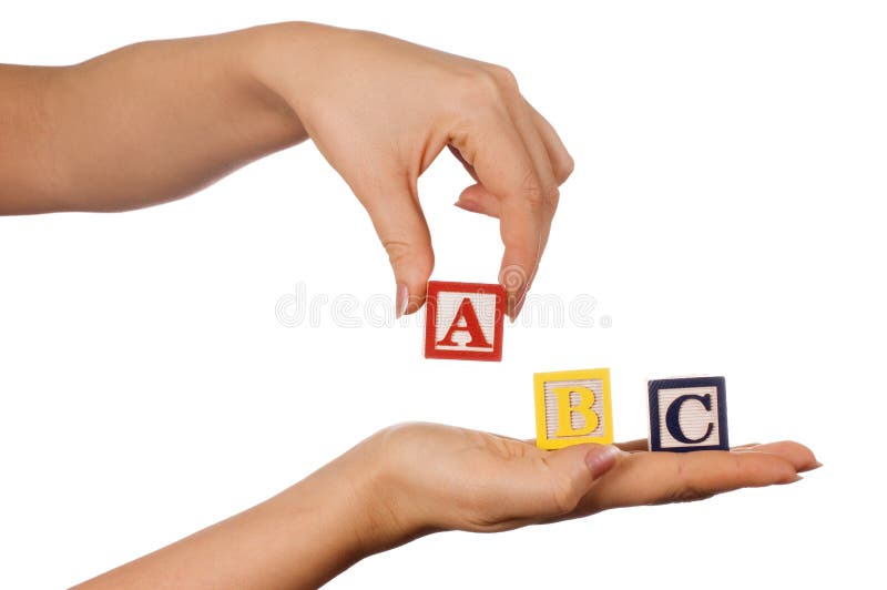 The hand holds a cube with letters