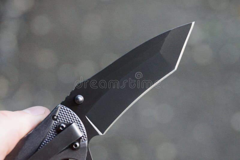 Hand Holds Folding Knife with Black Blade Stock Photo - Image of hold ...
