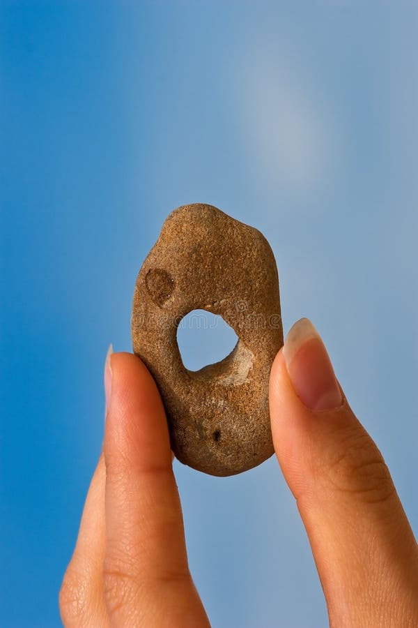 Hand with holey stone stock photos