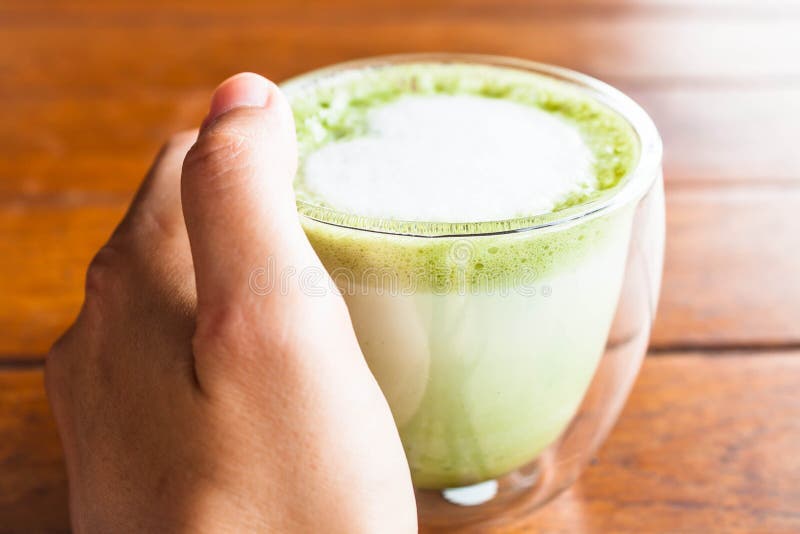 Hand on hot matcha green tea latte