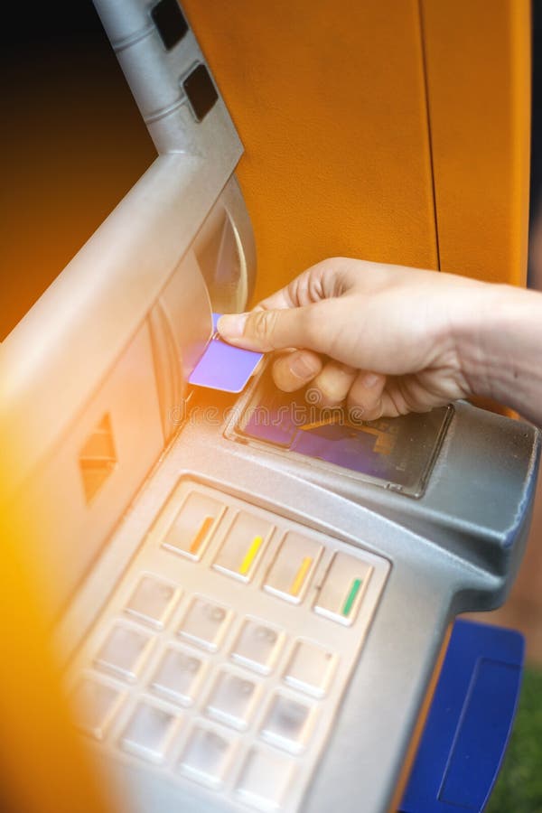 Hand Inserting ATM Card into ATM Bank Machine for Withdrawing Money