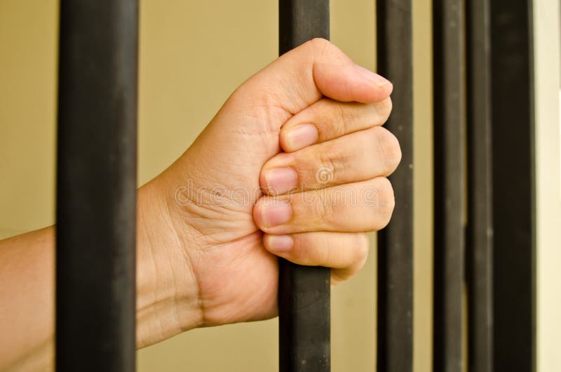 Hand on a jail bar royalty free stock photo