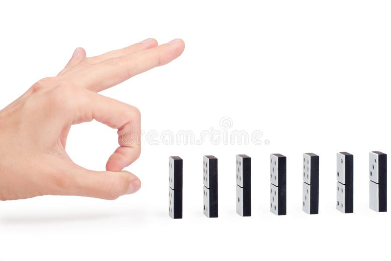 Hand ready to push domino pieces to cause chain reaction. Hand ready to push domino pieces to cause chain reaction