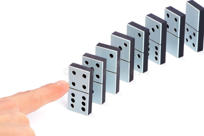 Hand ready to push domino pieces to cause chain reaction. Hand ready to push domino pieces to cause chain reaction