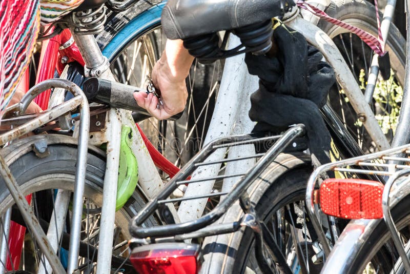 Hand Locking with a Key Her Bike with Bicycle U Lock Stock Photo