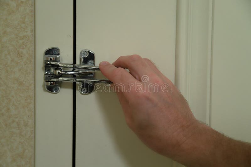 A locked metal door hook on white wooden door, simple device for home house  safety and protection Stock Photo