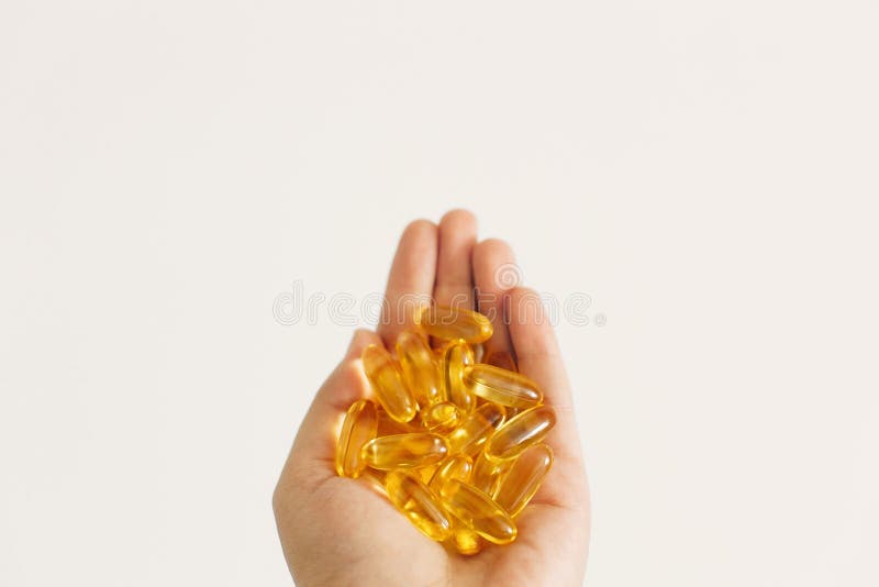 Hand med omega 3 kapslar i vit väggbakgrund Morgondos av vitamin Fiskolja i piller Hälsovård och behandling arkivfoto Hand med omega 3 kapslar i vit väggbakgrund Morgondos av vitamin Fiskolja i piller Hälsovård och behandling arkivfoto