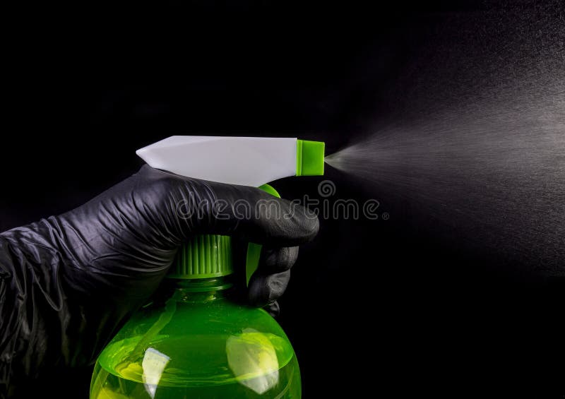 Hand in medical black gloves spraying sanitizer. Coronavirus