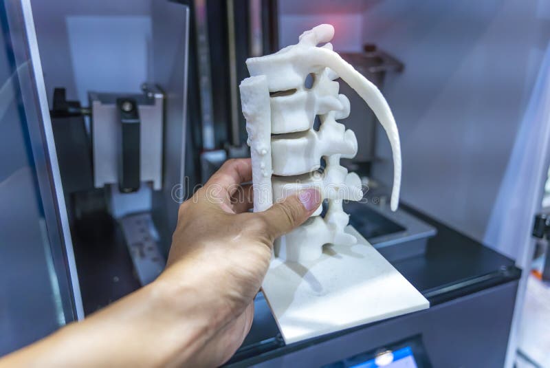 Hand with 3d printed human spine in 3d printer. Hand with 3d printed human spine in 3d printer