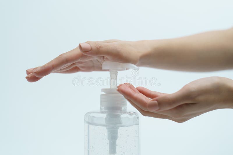 Hand mit Handdesinfizierer in einer klaren Pumpflasche auf einem weißen Hintergrund stockfoto