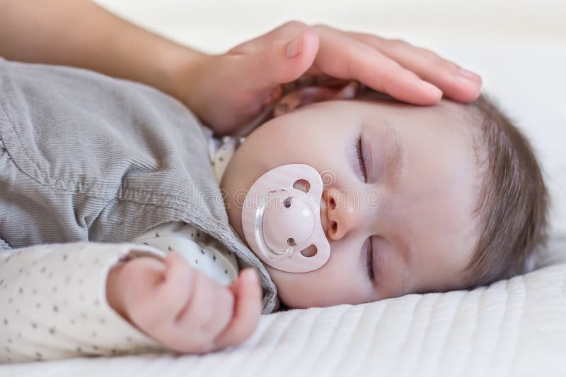 Hand of mother caressing her baby girl sleeping