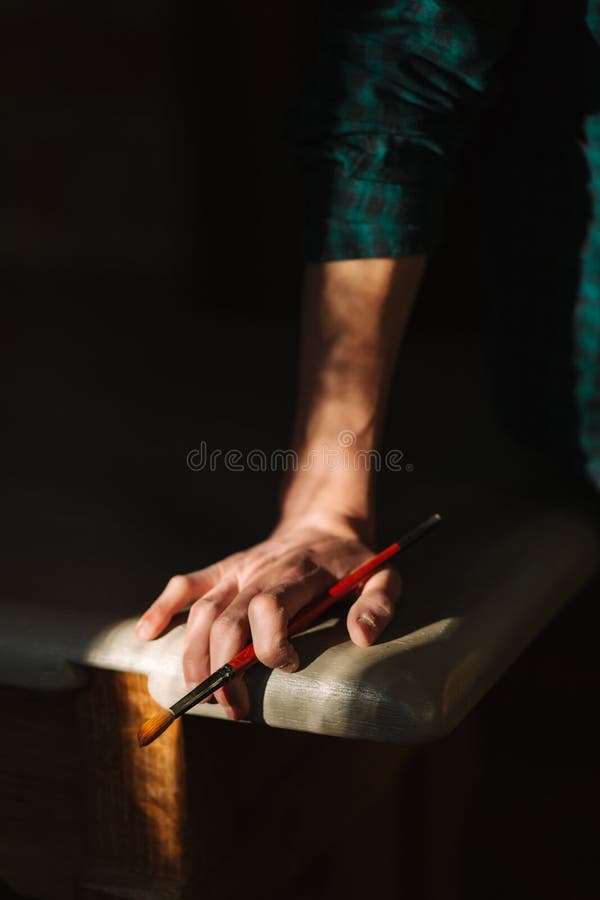 Hand o artist with a brush. Sun rays fall on table and hand stock photos Hand o artist with a brush. Sun rays fall on table and hand stock photos