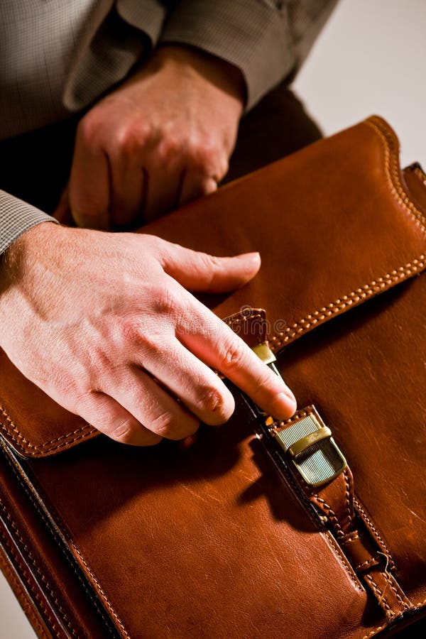 Business man opening elegant brown leather briefcase. Business man opening elegant brown leather briefcase.