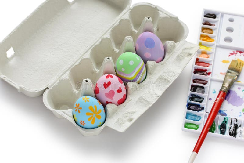 Hand painted easter eggs in egg box on white background