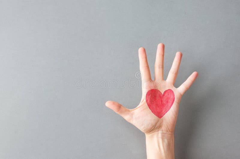 Hand palm of young Caucasian woman girl with painted on red heart on gray wall background. Charity love donation Valentine health royalty free stock photos Hand palm of young Caucasian woman girl with painted on red heart on gray wall background. Charity love donation Valentine health royalty free stock photos