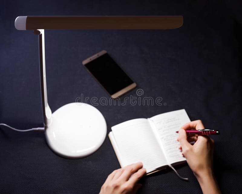 Hand with pen and notepad in the light.