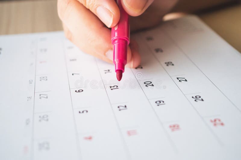 Hand with Pen Writing on Calendar Page Closeup Stock Image - Image of