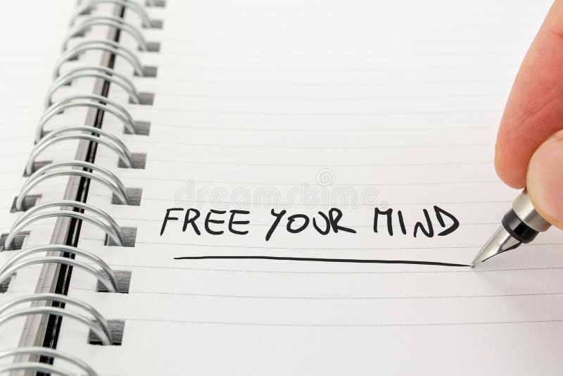 Hand with Pen Writing Free Your Mind in Notebook stock photography Hand with Pen Writing Free Your Mind in Notebook stock photography